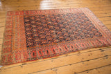 Corner of antique Mission Malayer rug, featuring fuschia raspberry boteh border, navy field, and subtle edge wear.