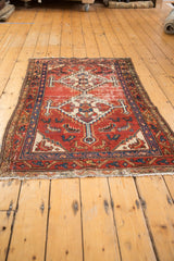 Vintage Hamadan rug with geometric double medallion, Herati field motifs, and wear on brick red.