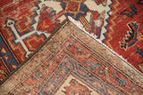 Vintage Hamadan rug corner showcasing geometric red, blue patterns, fringe, and woven foundation.