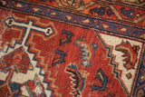Intricate stepped geometric motifs and wear on a vintage Hamadan rug field in brick red, navy, and ivory.