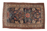 Antique Kurdish Bijar rug, late 19th century, displaying oversized floral motifs on a navy field.