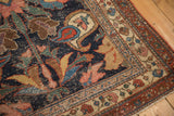 Antique Kurdish Bijar rug corner: navy with blush, green, saffron patterns, and visible foundation.