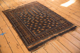 Tattered fringe and geometric terracotta, navy border of the antique Belouch rug.