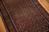 Antique Belouch rug's repeating trellis floral field and geometric border, navy, terra cotta, sand.