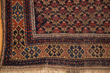Belouch rug's hand-knotted fringe and geometric border in navy, terra cotta, sand.