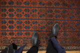 Deep madder root red pile with sky blue germinating floral motifs on an antique Belouch rug.