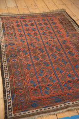 Deep madder red, sky blue geometric floral columns on a hand-knotted Antique Belouch rug.