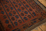 Antique Belouch rug corner showing deep madder red, sky blue geometric florals and secure selvage.