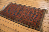 Antique Belouch rug with germinating geometric florals in madder red, sky blue, and charcoal.