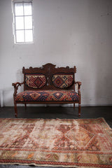 Geometric triple medallion design of the antique Caucasian rug, showing storied wear.