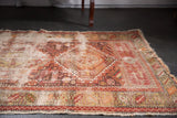Aged fringe and intricate geometric patterns in wine red, chestnut, ivory on an antique Caucasian rug.