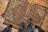 Antique Caucasian rug features allover tangerine boteh, slate blue ground, serrated ivory spandrels.