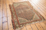 Antique Caucasian rug corner with lightning serrated border, teal boteh pattern, and aged patina.