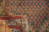 Antique Caucasian rug: folded view showing hard wear, exposed foundation, and tattered fringe.