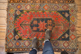 Geometric border and tattered fringe detail on a vintage Caucasian rug corner.