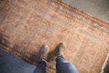 Antique hand-knotted Lilihan runner with floral lattice, soft raspberry, sky blue, and even wear.