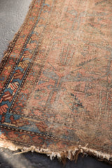 Worn antique Lilihan rug corner revealing exposed foundation, tattered ends, and faded blue, raspberry.