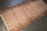 Antique Lilihan runner's worn end, showing hard tatter, with faded dusty raspberry floral border.