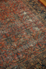 Vintage Mahal carpet's madder root red field, displaying knot wear and henna plan design.