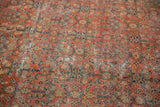 Vintage Mahal carpet detail with henna pattern in madder red and navy, showing wear to foundation.