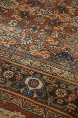 Mahal carpet: chestnut rust floral field, navy samovar border, and worn pile texture.