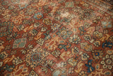 Close-up of vintage Mahal carpet's floral pattern, chestnut rust, with mostly even wear and foundation showing.