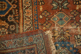 Mahal rug corner revealing hand-knotted foundation, worn pile in rust and blue, and fringe.
