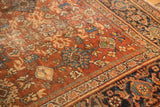 Patinaed chestnut brown floral field and navy samovar border of a vintage Mahal rug.
