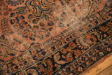 Traditional antique Lilihan rug's dusty rose field, navy floral border, and wear across knot heads.