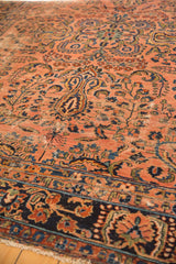 Persian Lilihan carpet's dusty rose field, navy border, floral patterns, and wear.