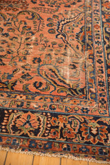 Worn pile of an antique Lilihan carpet, revealing foundation, dusty rose field, and navy border.