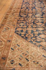 Vintage Hamadan runner's navy Herati motif and sand starburst spandrel, with mostly even wear.