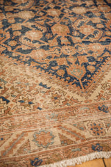 Vintage Hamadan rug's light border with sand, terracotta patterns, subtle wear, and fringe.