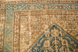 Distressed vintage Hamadan rug corner with aqua blue and antique ivory patterns.