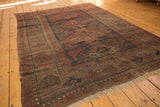 Antique Belouch carpet: serrated diamond medallion, geometric field, navy, red, and brown.