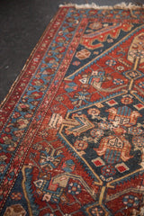Antique Hamadan rug border, intricate geometric motifs in deep red, navy, sky blue, patinated pile.