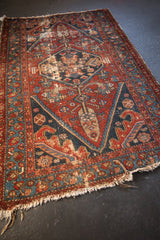 Light tatter and foundation showing at the corner of the antique Persian Hamadan rug.