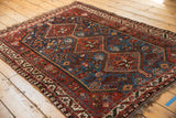 Stepped rust red medallion and sapphire blue field with geometric florals on a vintage Afshar rug.