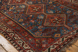 Geometric floral and animal motifs in sapphire blue and rust red on a vintage Afshar rug.