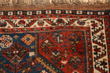 Vintage Afshar rug corner with geometric floral motifs in sapphire blue and dark rust red.