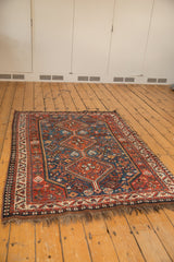 Vintage Persian Afshar rug corner detail with geometric border, dark fringe, and rust red field.