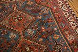 Vintage Afshar rug corner with geometric florals, sapphire blue field, and rust red border.