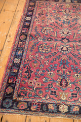 Detail of antique Kerman rug, delicate cochineal red field with sprawling floral vinery in navy and beige.