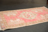Original side cord selvage and distressed pink and ivory pile of an Oushak rug.