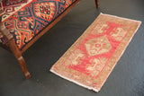Vintage distressed Oushak rug mat with a muted pink-red field and subtle beige medallion.