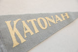 Cream-colored Katonah lettering on the textured surface of a grey wool felt pennant.