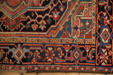 Close-up on the classic turtle samovar border of a vintage Heriz rug showing its hand-knotted texture.