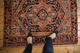 View from above showing the bold geometric medallion and turtle border on a vintage Heriz rug.