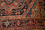 The hand-knotted pile and classic turtle samovar border of a vintage Heriz rug in rich traditional colors.