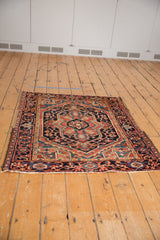 Angled view of a square vintage Heriz rug displaying its full concentric lozenge medallion pattern.